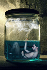 Naked guy smokes underwater in a jar