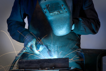 Worker welding steel close up.