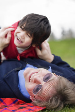 Father playing with disabled son on grass at park