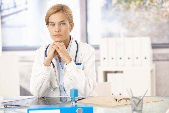 Young female doctor sitting at desk