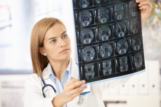 Young radiologist looking at x-ray image