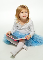 Small girl reading a book and smiling