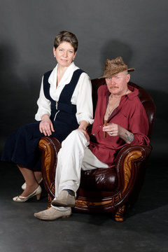 Mid-aged couple sitting in leather armchair