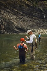 Father And Sons Fly Fishing In Mountain River