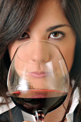 young brown woman smelling a glass of red wine - 31373074