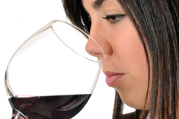 young brown woman smelling a glass of red wine