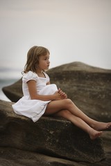 Fototapeta na wymiar Girl Sitting On A Rock