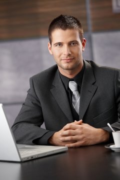 Confident businessman sitting at meeting table