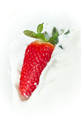 strawberry splashing into milk