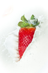 strawberry splashing into milk