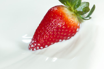 strawberry splashing into milk