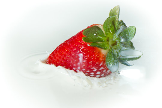 strawberry splashing into milk