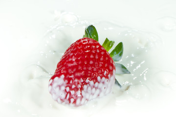 strawberry splashing into milk