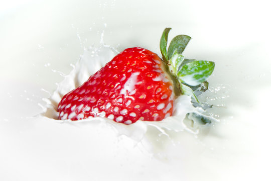 strawberry splashing into milk