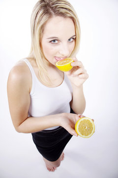 Frau leckt an Zitrone