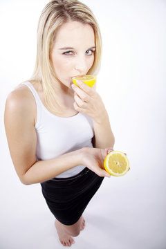 Frau beisst direkt in Zitrone