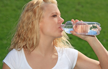 Attraktive Frau trinkt aus einer Wasserflasche