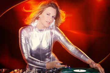 DJ Disco mixt mit rotem Hintergrund am Mischpult Porträt