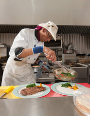 Chef placing completing serving with vegtables