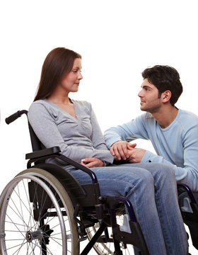 Mann tröstet Frau im Rollstuhl