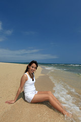 Fototapeta na wymiar コマカ島の砂浜で寛いでいる笑顔の女性