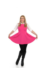 pretty woman in pink dress standing. studio shot. isolated