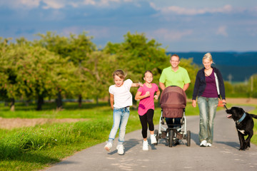Familie mit Kindern und Hund auf Spaziergang