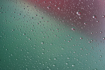 Fototapeta premium Капли воды крупным планом на разноцветном фоне