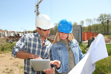 Engineers on construction site with plan