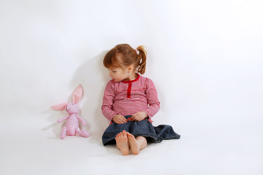 Kleines M&auml;dchen redet mit Kuscheltier