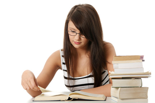 Young student woman with lots of books studing.