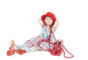 little girl tries on a mum's hat and a beads