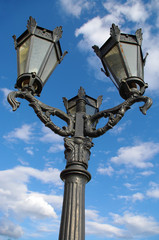 Fototapeta na wymiar Lampy uliczne na tle zachmurzonego nieba