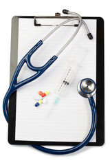 Note pad with blue stethoscope and pills