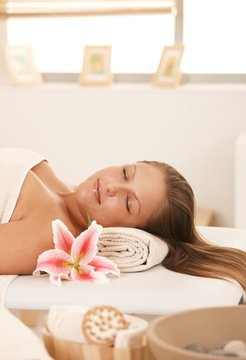 Closeup of young woman resting on massage bed