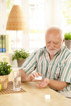 Senior man taking medication at home