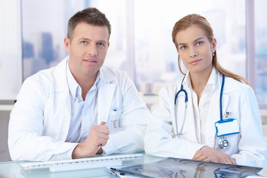 Young doctors sitting at desk consulting