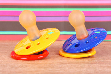 Baby silicone pacifiers in blue, red and yellow color,  on color
