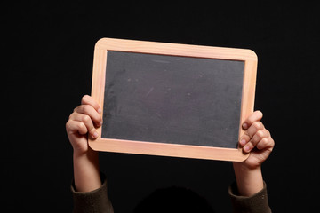 mani di bambino tengono una piccola lavagna