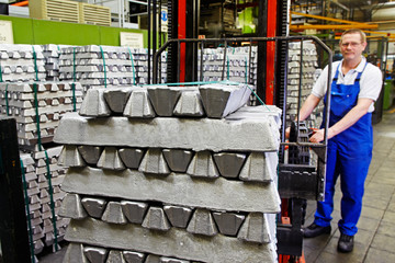 worker moving aluminum bars with a forklift