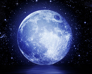 The full moon in the night sky reflected in water