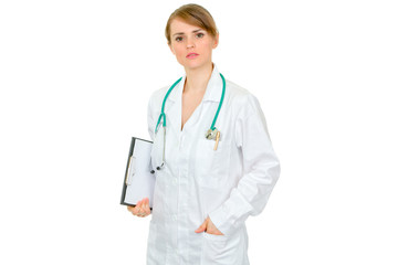 Thoughtful female medical doctor holding clipboard in hand