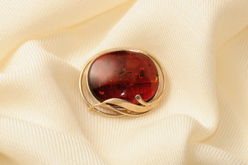 Golden brooch with amber on a shawl of cashmere and silk