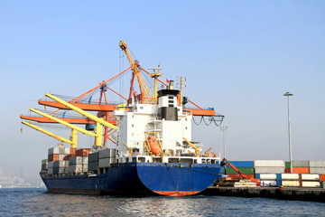 Naklejka premium Container ship under cranes at harbor