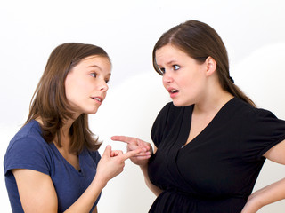 Sisters pointing their fingers at each other