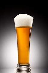 Beer into glass on a gray gradient