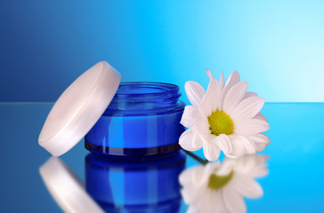 Obraz na płótnie Canvas Flower and cream on blue background