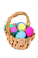 Easter colored eggs in the basket on the white background