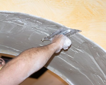 Men at work spreading plaster