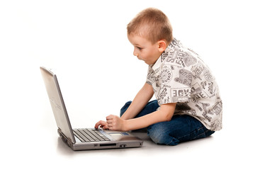 Cute boy playing with laptop